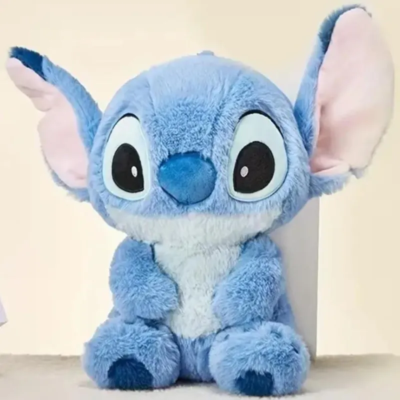 Peluche azul de Stitch sentado, con orejas grandes rosadas por dentro.